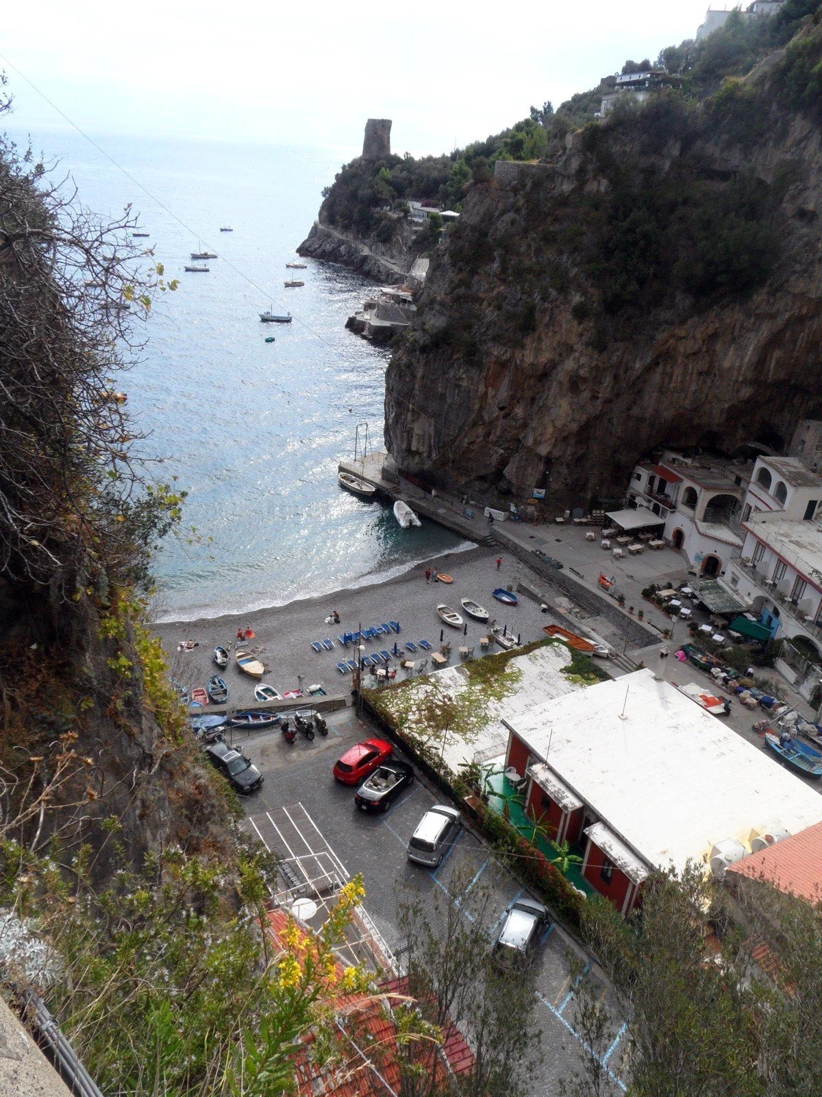 Marina di Praia の海沿いの石畳と漁船。狭い断崖に囲まれた雰囲気