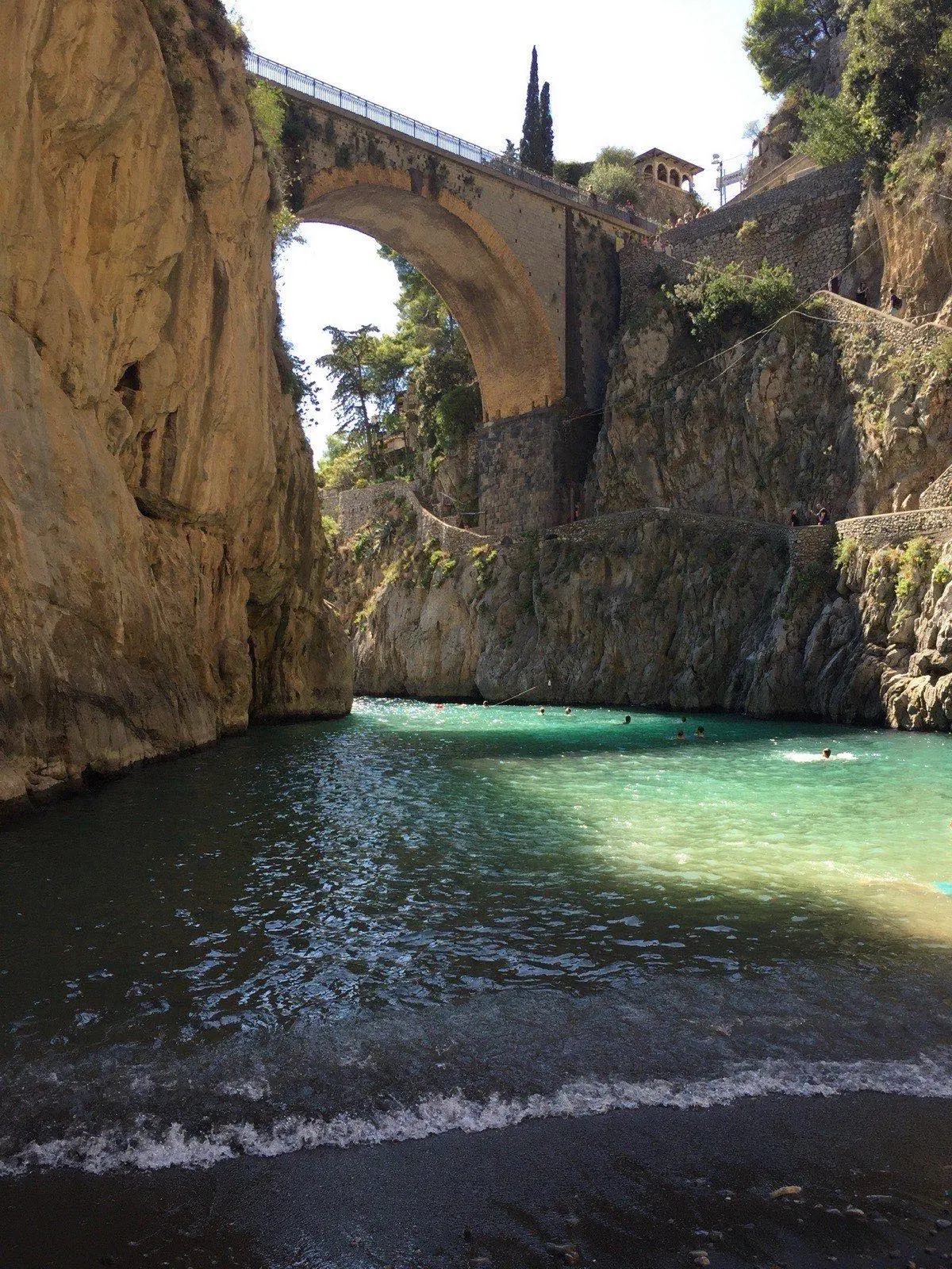 El puente del Fiordo di Furore visto desde el mar con los acantilados enmarcando la entrada estrecha