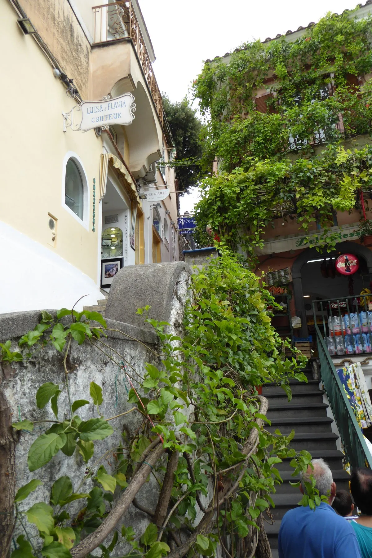 Cầu thang đá hẹp giữa các cửa hàng trong làng Positano