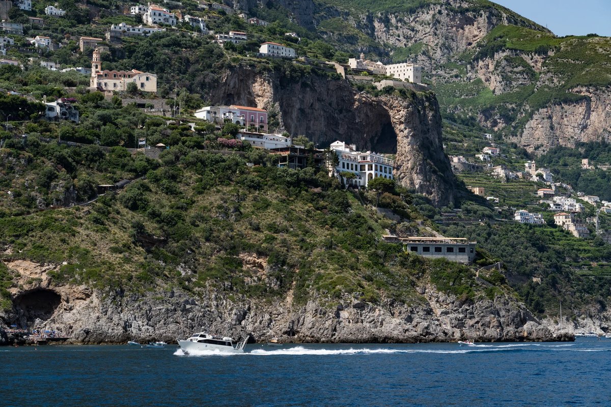 Vista panorámica de la Costa Amalfitana desde un ferry que muestra pueblos en acantilados y agua turquesa
