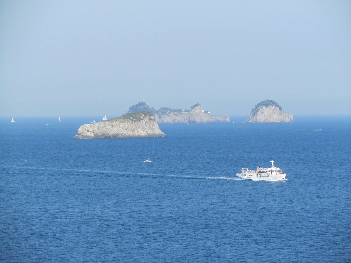 Pasajeros en la cubierta abierta de un ferry viajando por la Costa Amalfitana con vistas costeras