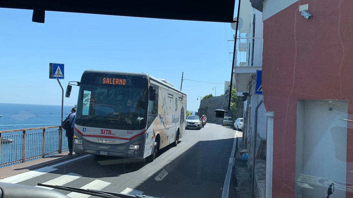Autobús SITA azul conduciendo por la carretera costera sobre el mar en la Costa Amalfitana