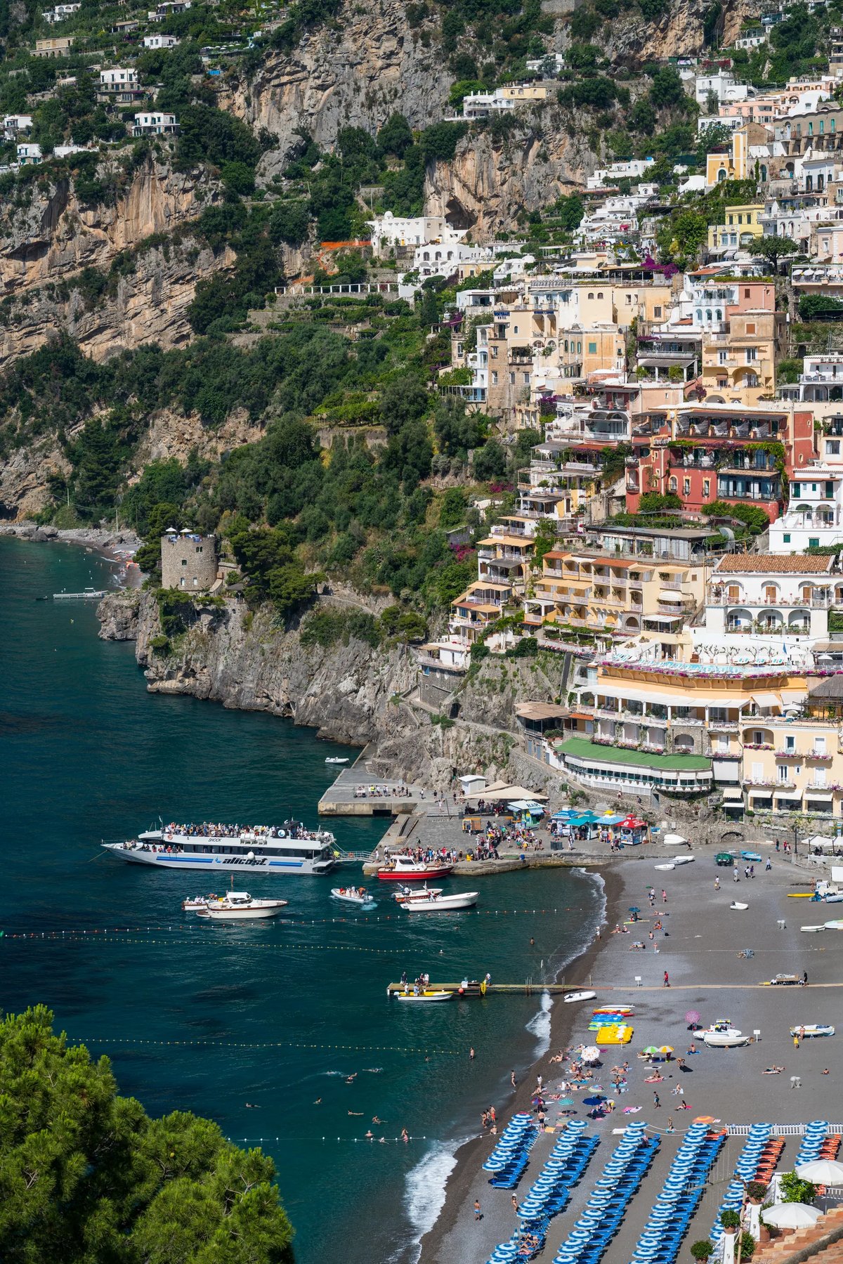 Spiaggia Grande en Positano con sombrillas de colores y barcos en la bahía