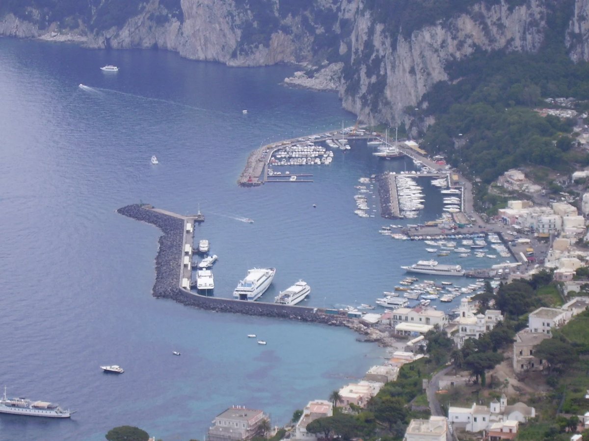 Puerto Marina Grande en Capri con ferris y puestos de billetes a lo largo del paseo marítimo
