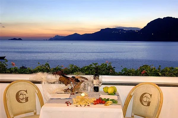 Terraza del La Gavitella Beach Club con vistas al mar y cena al atardecer