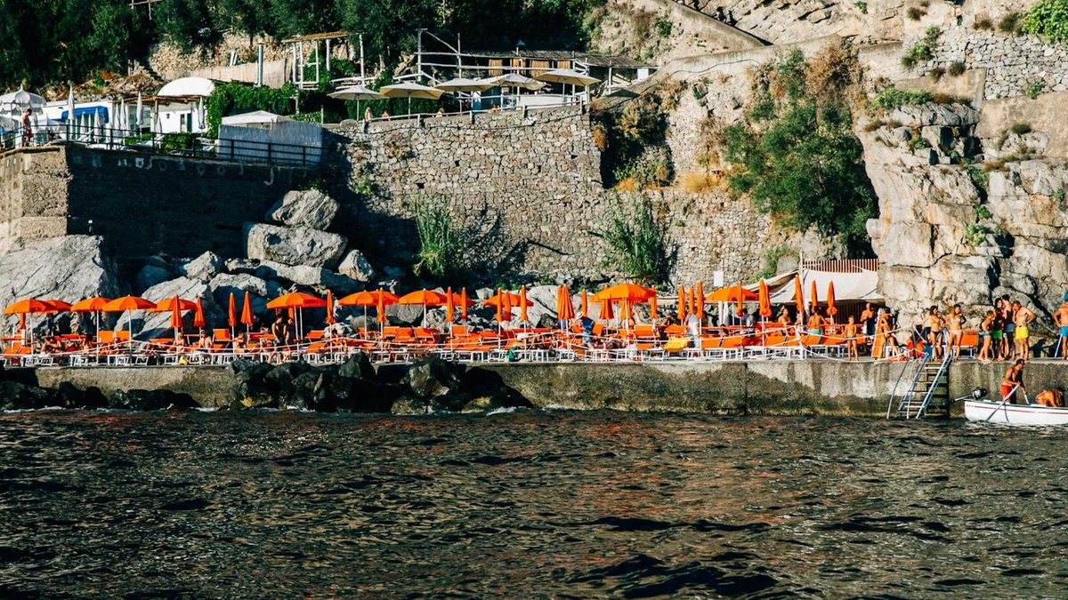 One Fire Beach Club con tumbonas brillantes, podio de DJ y ambiente de fiesta