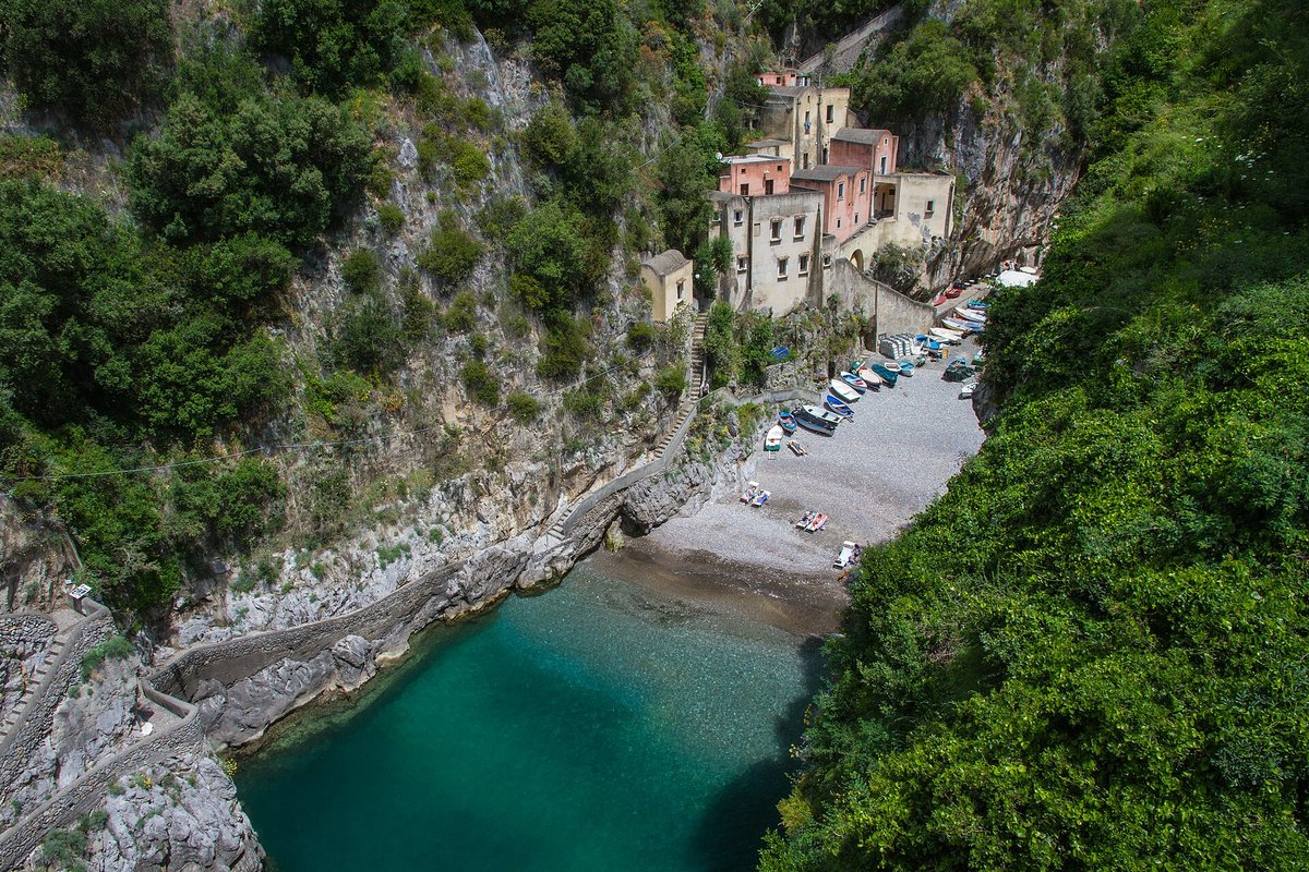 Playa de cantos rodados bajo el puente del Fiordo di Furore con acantilados a ambos lados