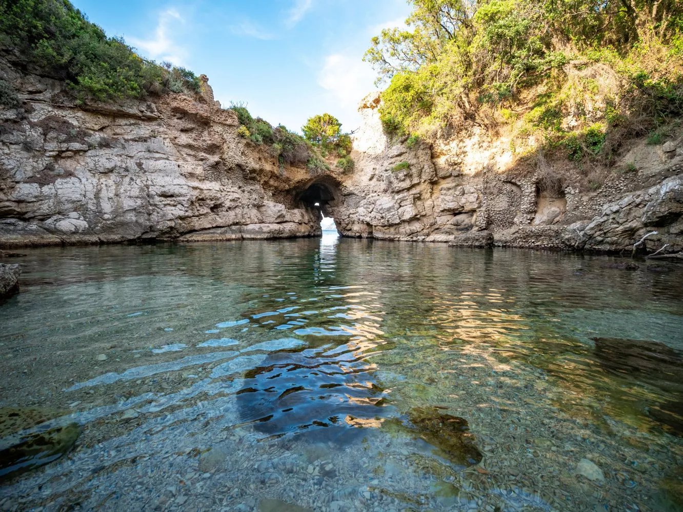 La piscina natural rocosa en Bagni della Regina Giovanna con un arco bajo que se abre al mar