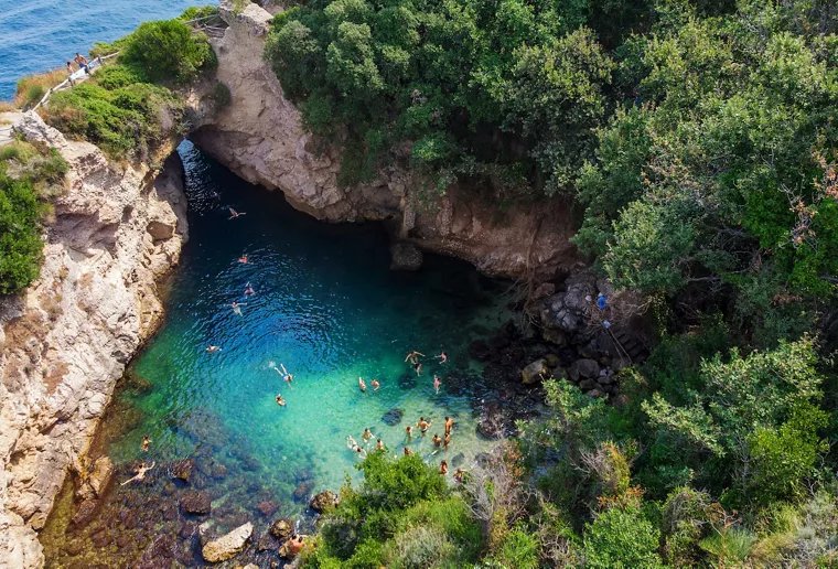 Piscina natural de Bagni della Regina Giovanna en Sorrento, vista desde arriba con nadadores en agua turquesa clara
