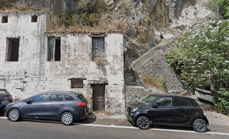 Casa blanca antigua junto a la escalera en la ruta de caminata del amanecer sobre Positano