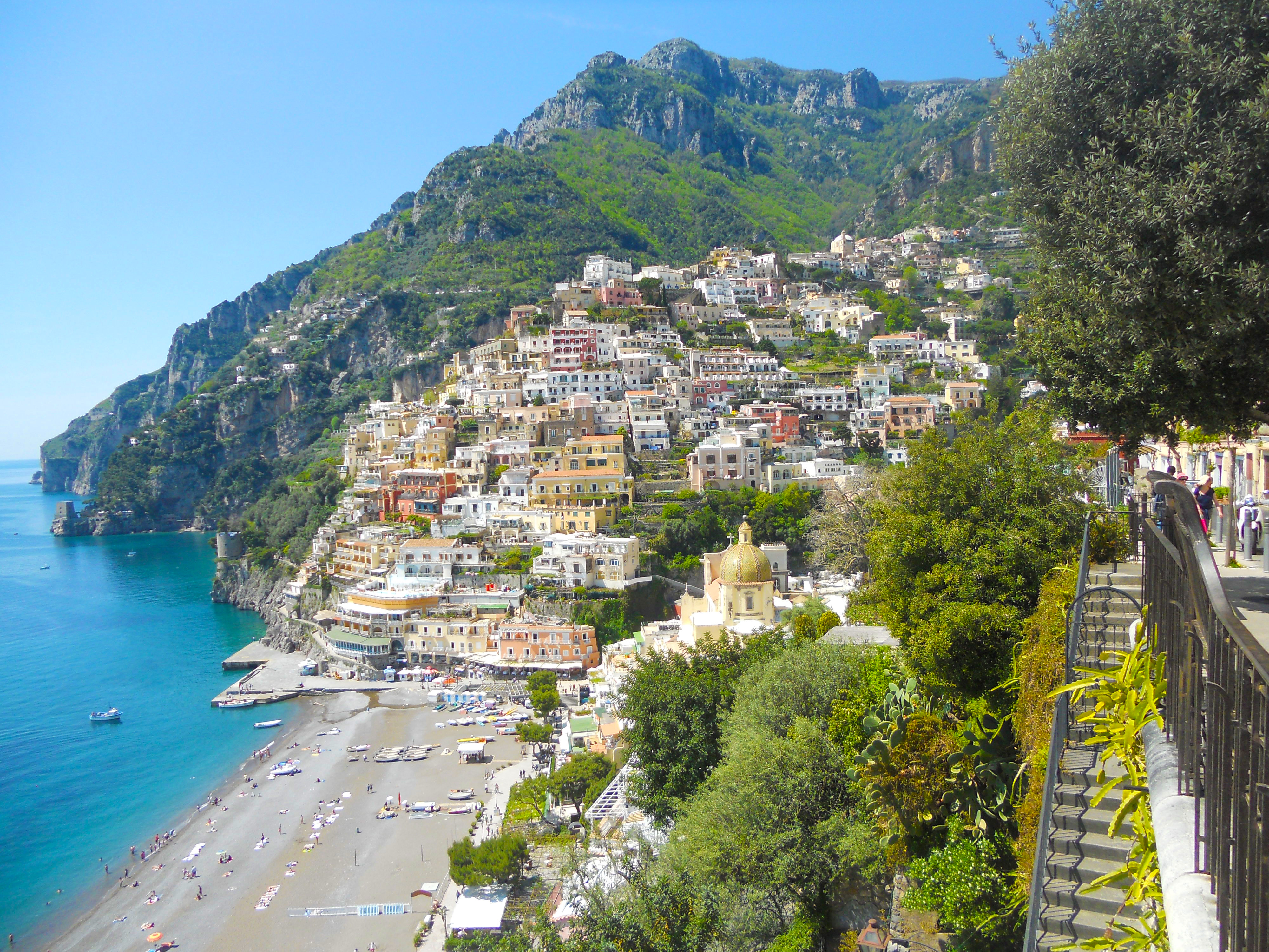 Weite Ansicht von Positano mit Strand, farbenfrohen Gebäuden und umgebenden Bergen
