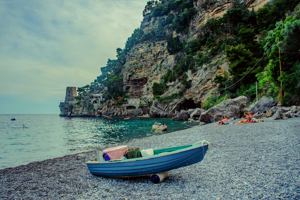 Pupetto Beach Club with orange loungers and restaurant on Fornillo beach