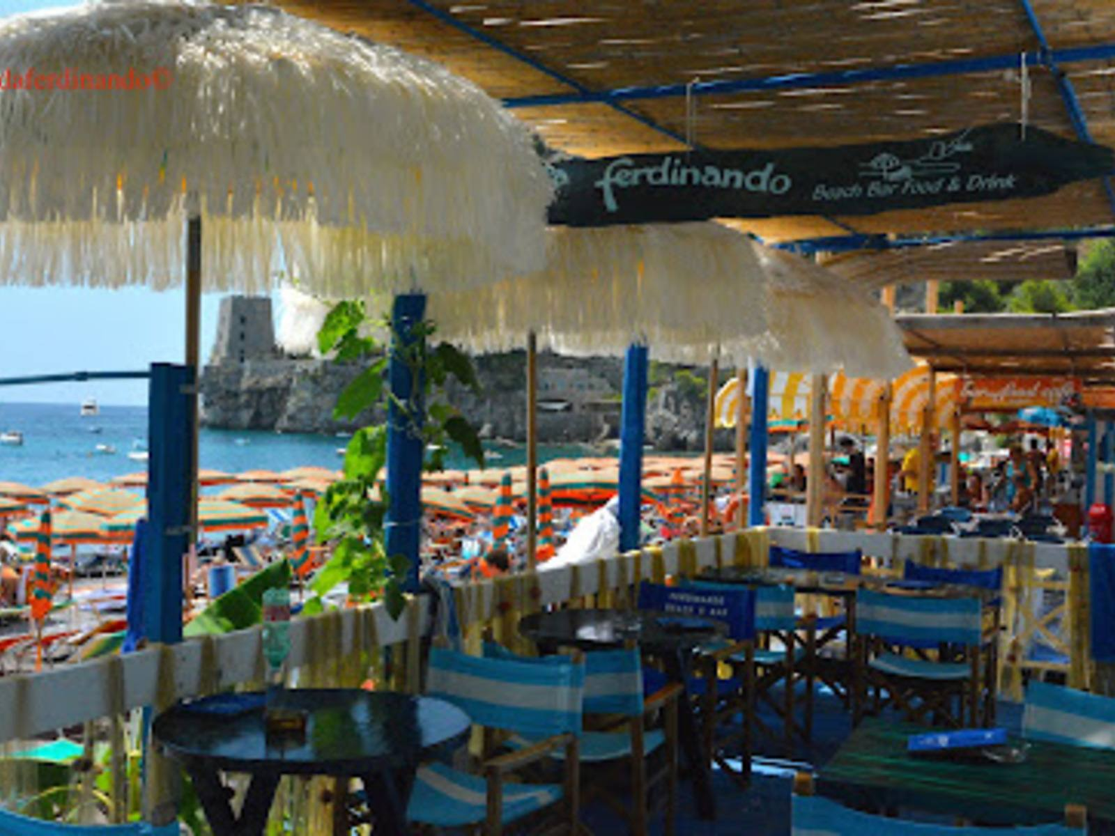 Fratelli Grassi Beach Bar with red loungers and shaded bar area at Fornillo