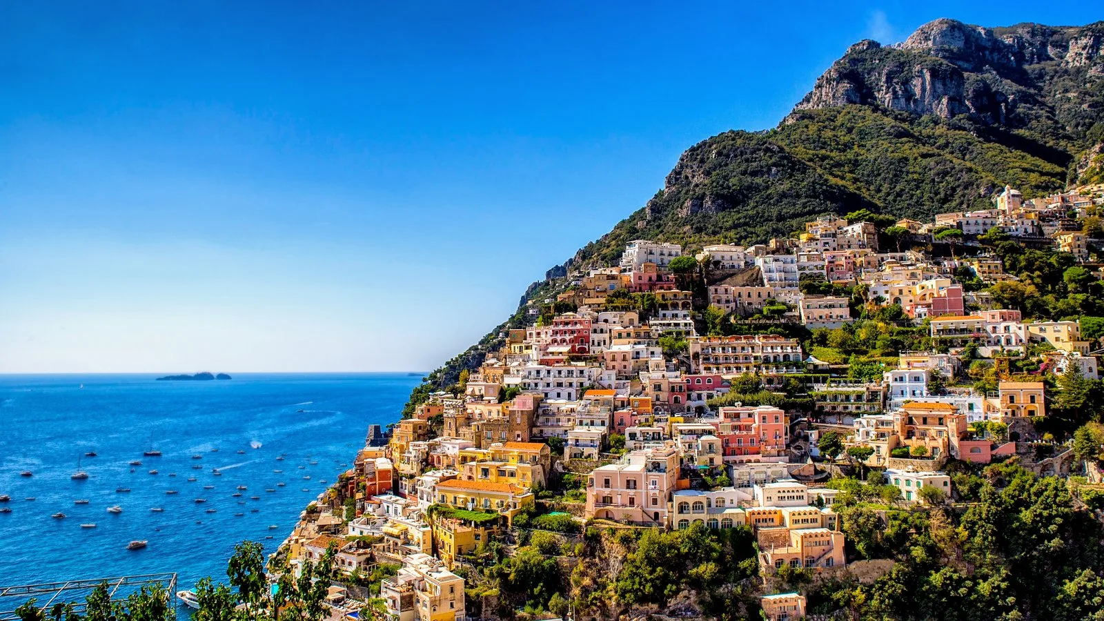 Panoramic view of Positano's colourful buildings cascading down the hillside to the sea